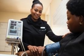 woman smiling taking blood pressure.