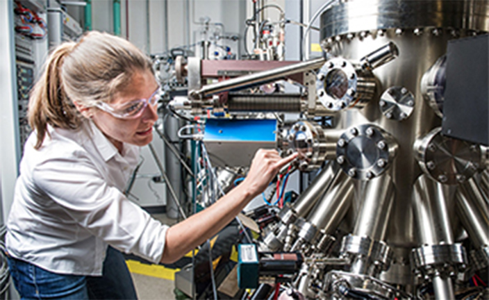 Woman inspecting manufacturing equipment.