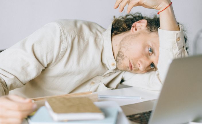 stressed man with head on desk at work.