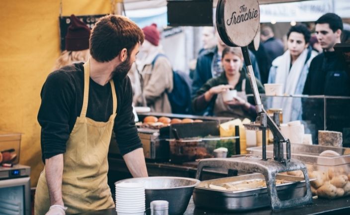 Worker serving line of customers.