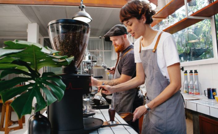 Man and woman working in coffee shop behind the counter.