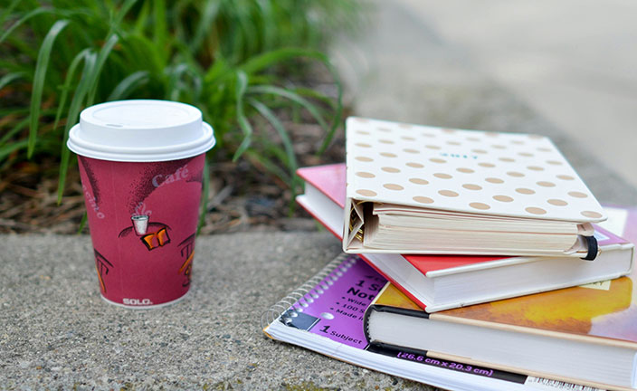 coffee and school books on concrete.