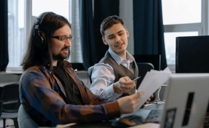 two men working together in an office.