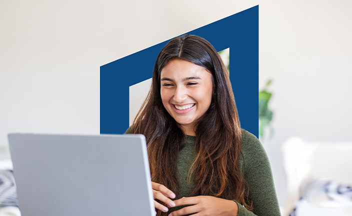 Girl smiling and studying on laptop.