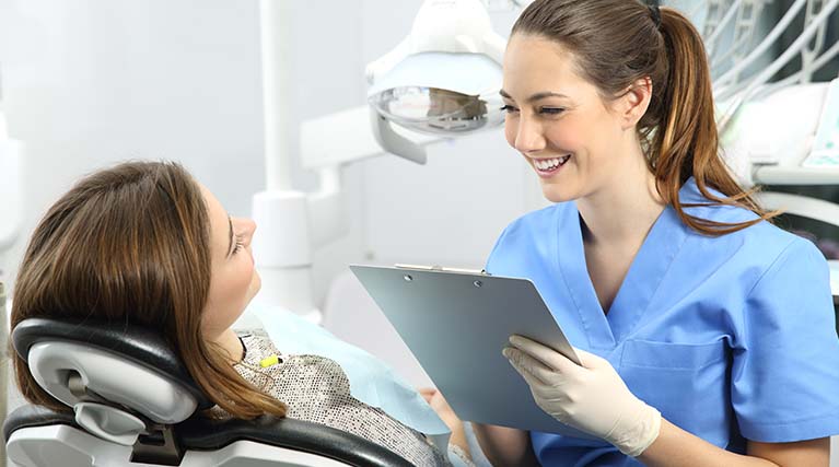 dental assistant talking with patient.