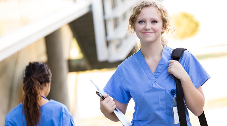 healthcare professional walking with charts.