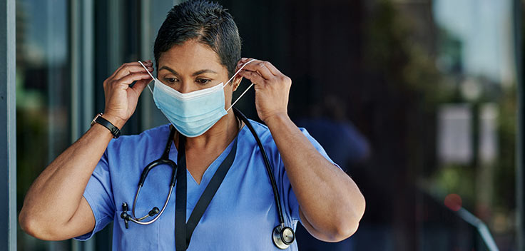 Medical Assistant puts on her facemask before work.