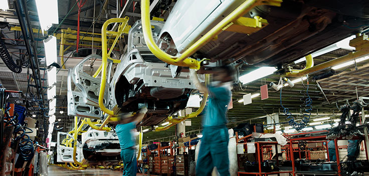 Automotive manufacturers working on an assembly line.
