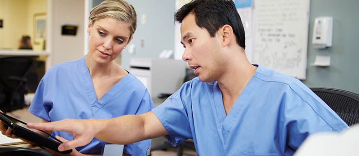 two medical terminologist reading computer tablet.