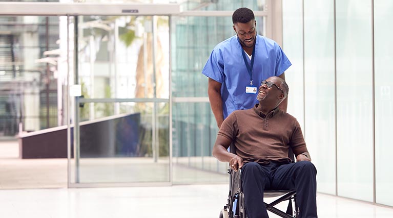 medical professional transporting a patient in a wheelchair.