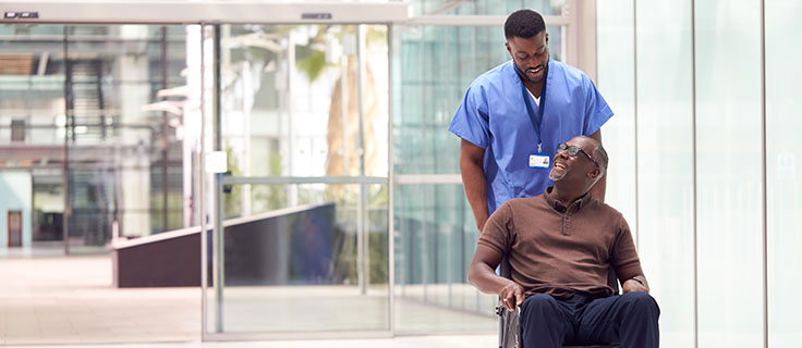 medical professional transporting a patient in a wheelchair.